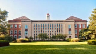 College academic building in front of green lawn