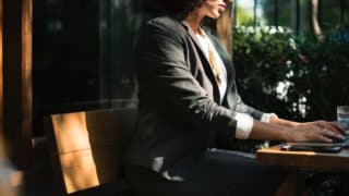 woman writing at desk in cafe