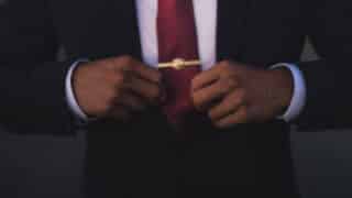 hands straightening necktie