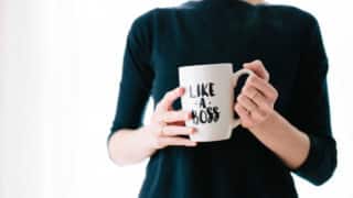 woman holding coffee mug that says