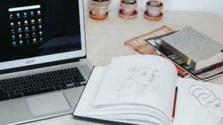 open notebook on table next to laptop
