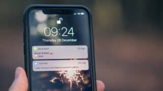 iPhone lock screen with notifications from WhatsApp and Twitter