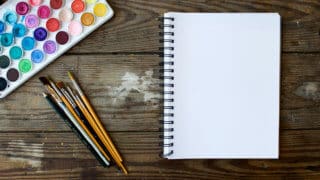 Watercolor set with paint brushes and notebook