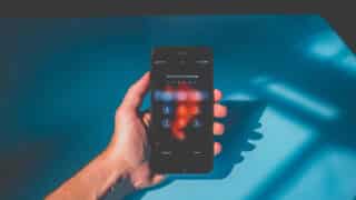 hand holding iPhone with passcode screen open