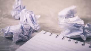 Crumpled pieces of paper next to notepad