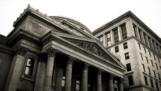 Bank with classical facade in front of apartment building