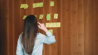 Person arranging sticky notes on a wall