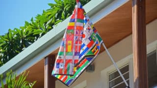 Flag composed of many other flags flying in front of a school