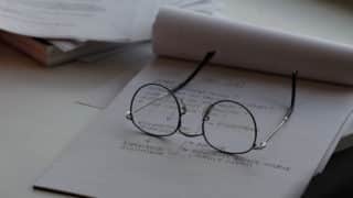 Wire-rimmed eye glasses on legal pad with flowchart