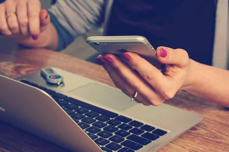 hand-holding-phone-in-front-of-keyboard