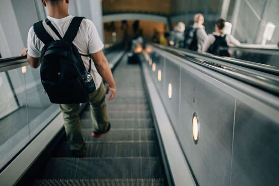 man-escalator-with-backpack