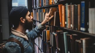 Man taking book off library shelf