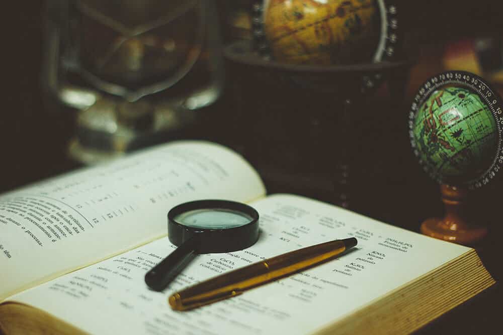 magnifying glass and pen on book