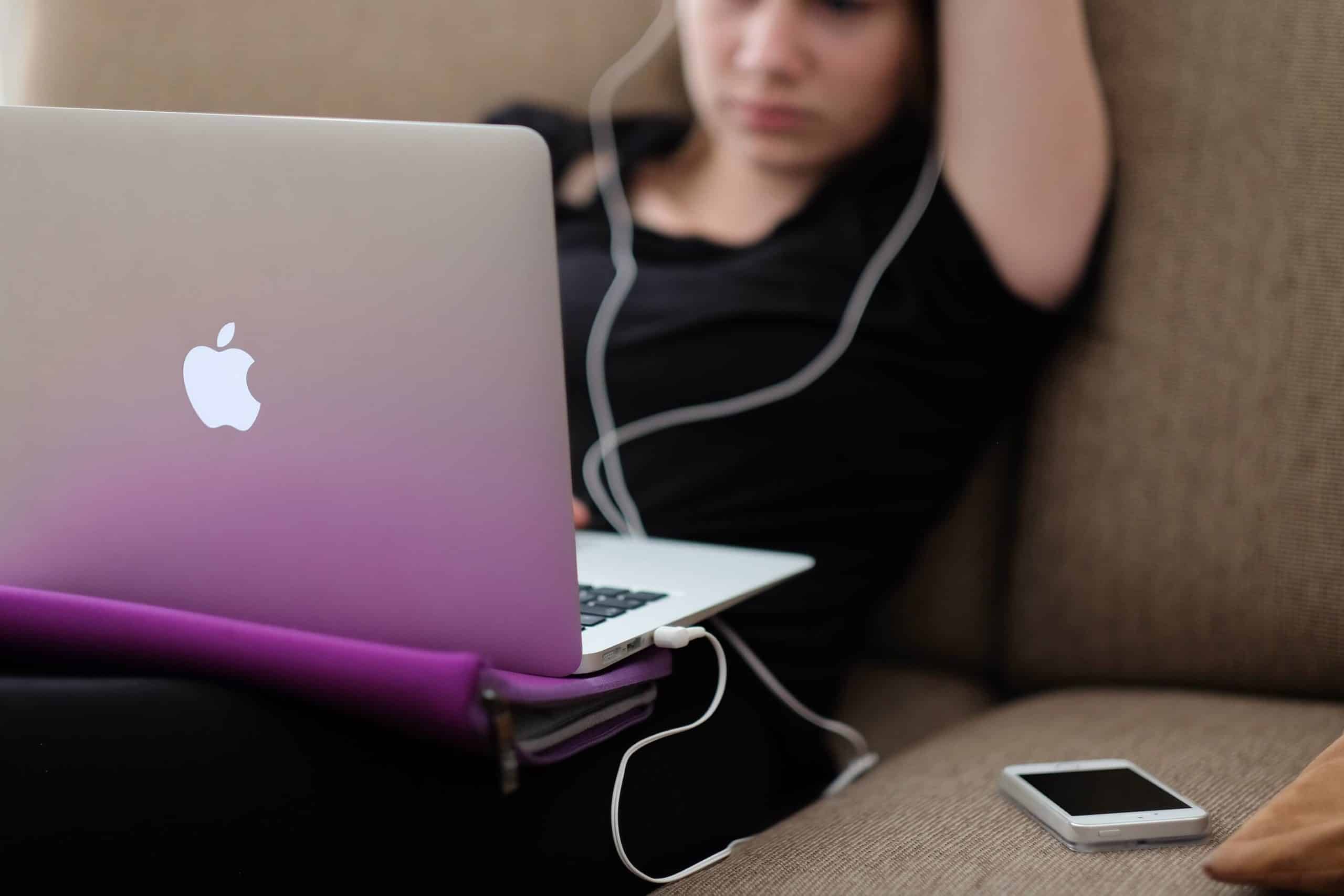 girl with macbook sitting on couch