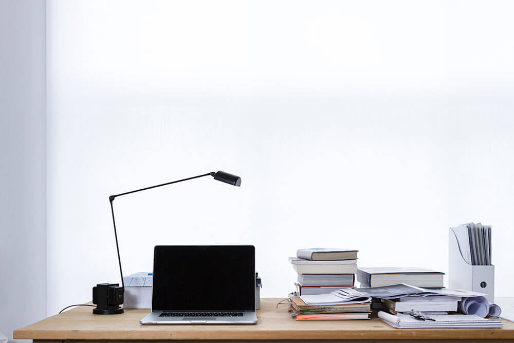 laptop books and lamp on desk