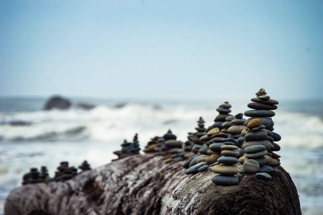 piles of pebbles balanced in front of ocean