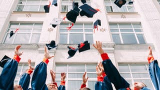 graduates throwing caps into the air