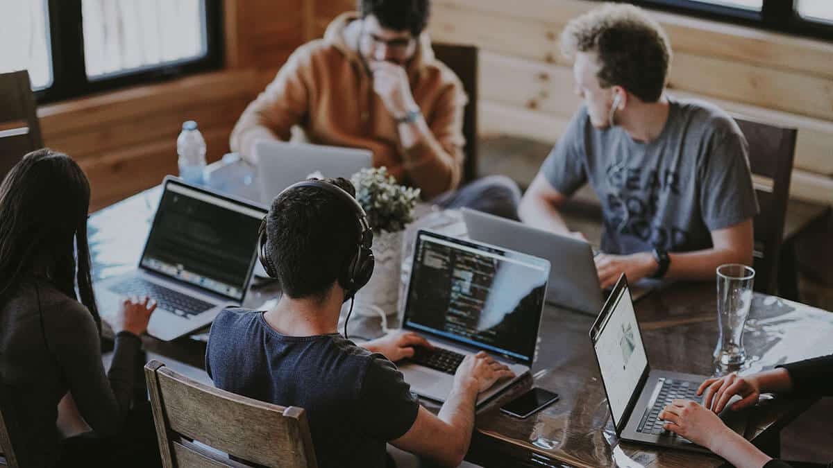 Group of people working on laptops at a table