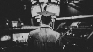 Student in graduation cap entering arena