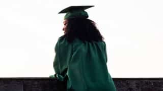 Woman in graduation gown looking into the distance
