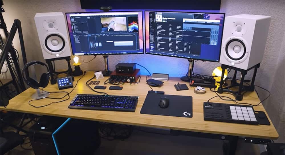 Wider Jarvis standing desk with dual monitors, speakers, keyboard, and mouse