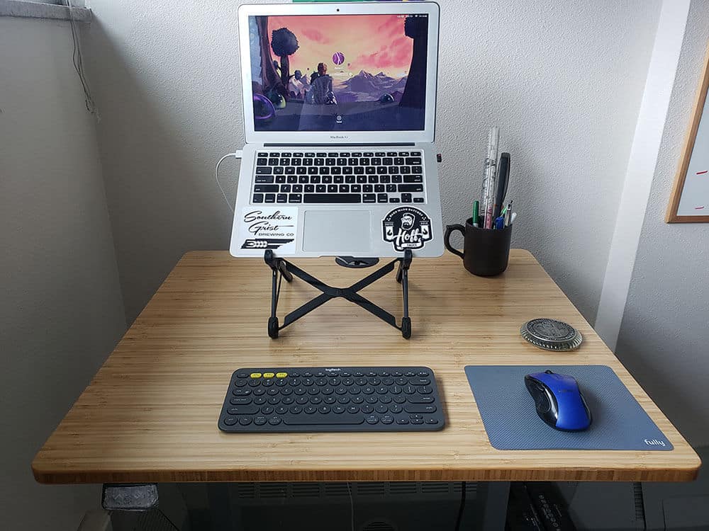 firkantet Jarvis stående skrivebord med tastatur, mus og bærbar computer på stativ