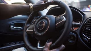 Driver's hands turning steering wheel